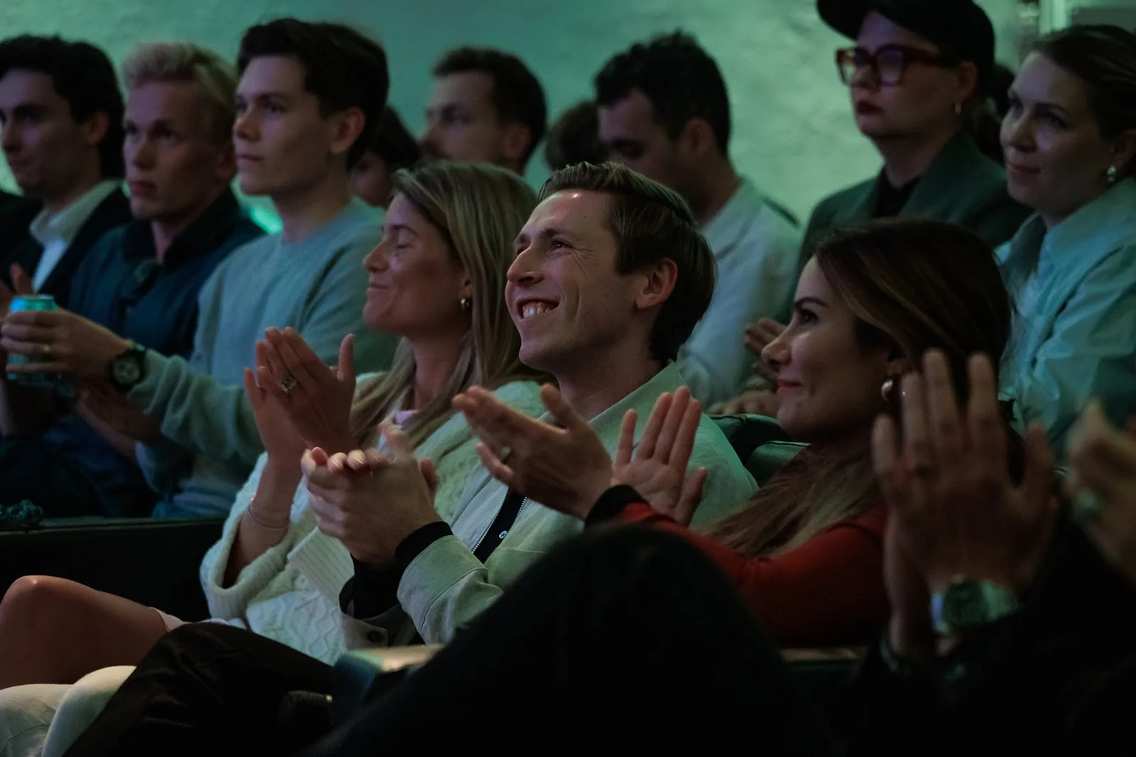 Smiling audience members clapping in the front row. Stockholm.
